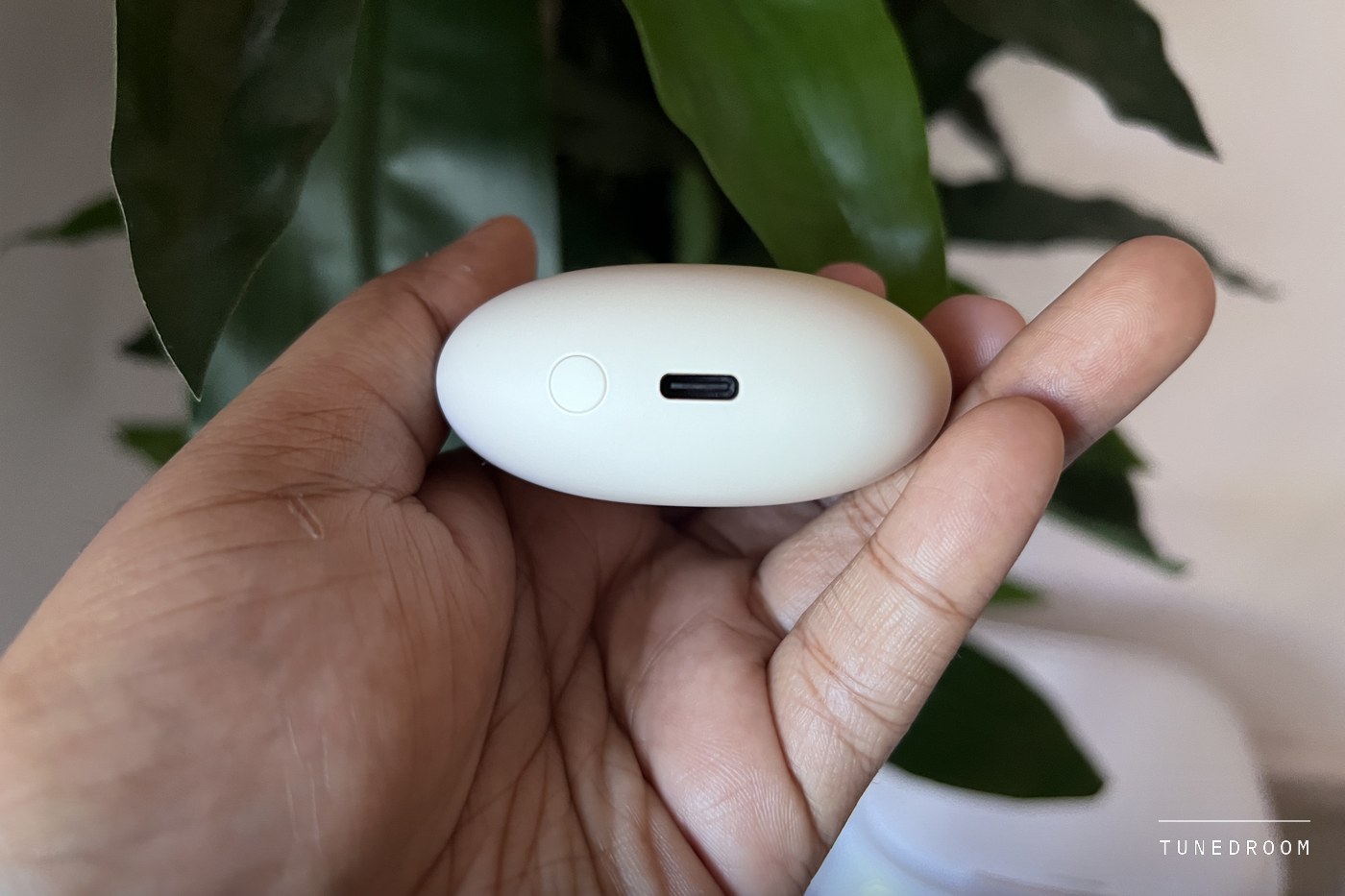 The edge of the Bowie MC2 case held between fingers, showing its USB-C port and a round button beside it