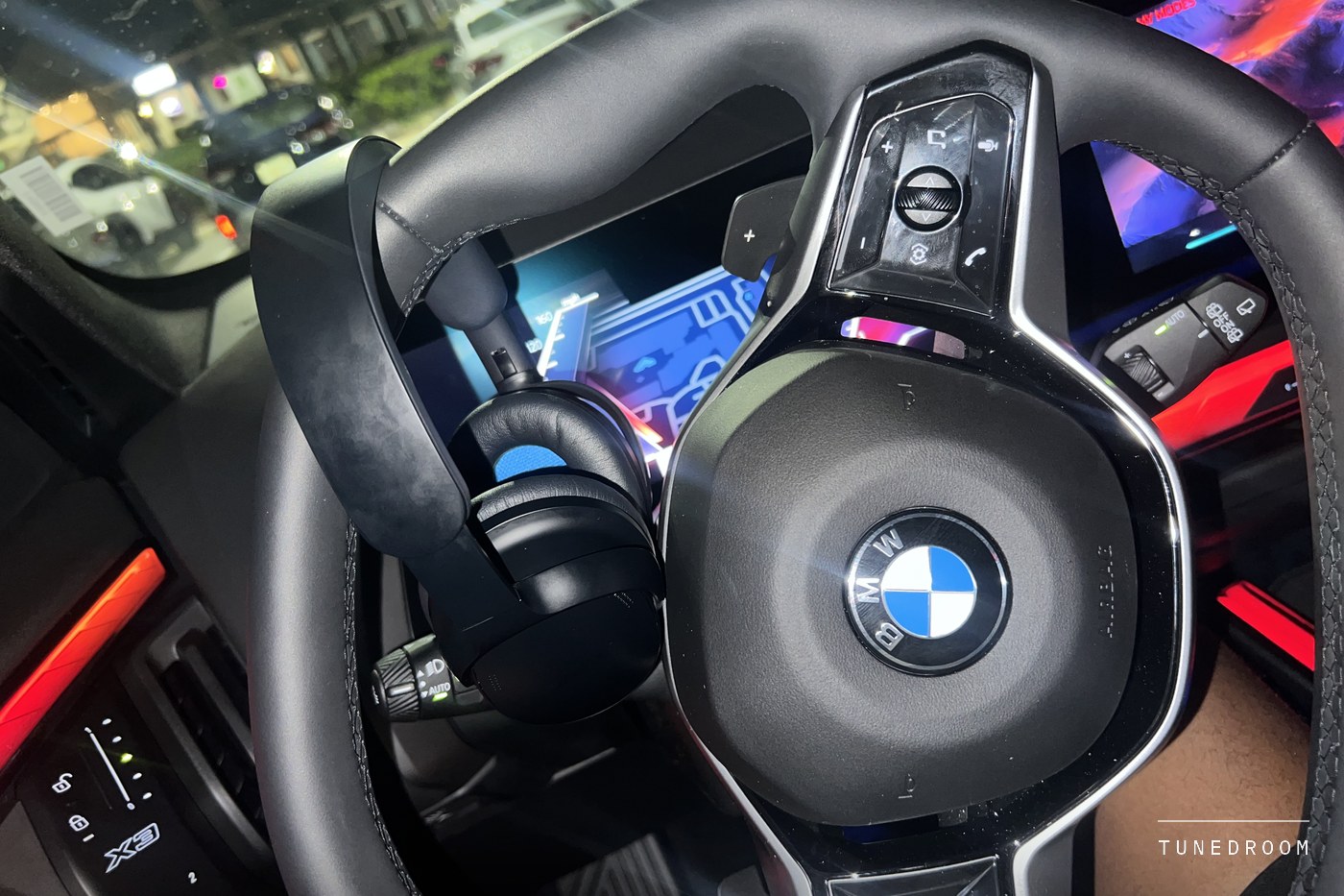 The headphones resting on a car steering wheel at night