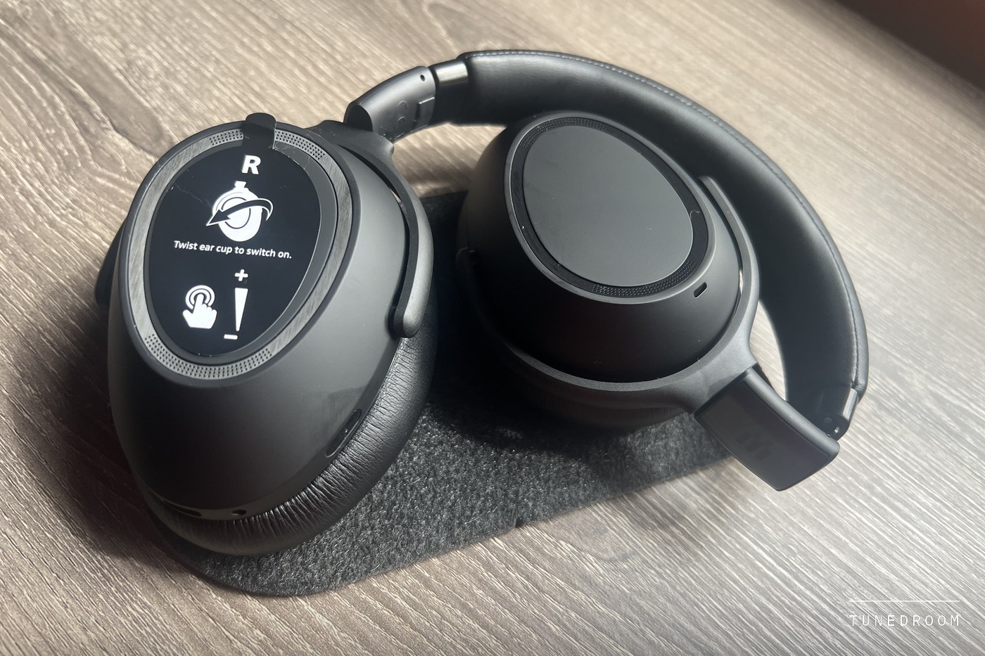 The right earcup of a new Adapt 660 with its instruction film reading Twist ear cup to switch on, above icons for a tap and a volume swipe