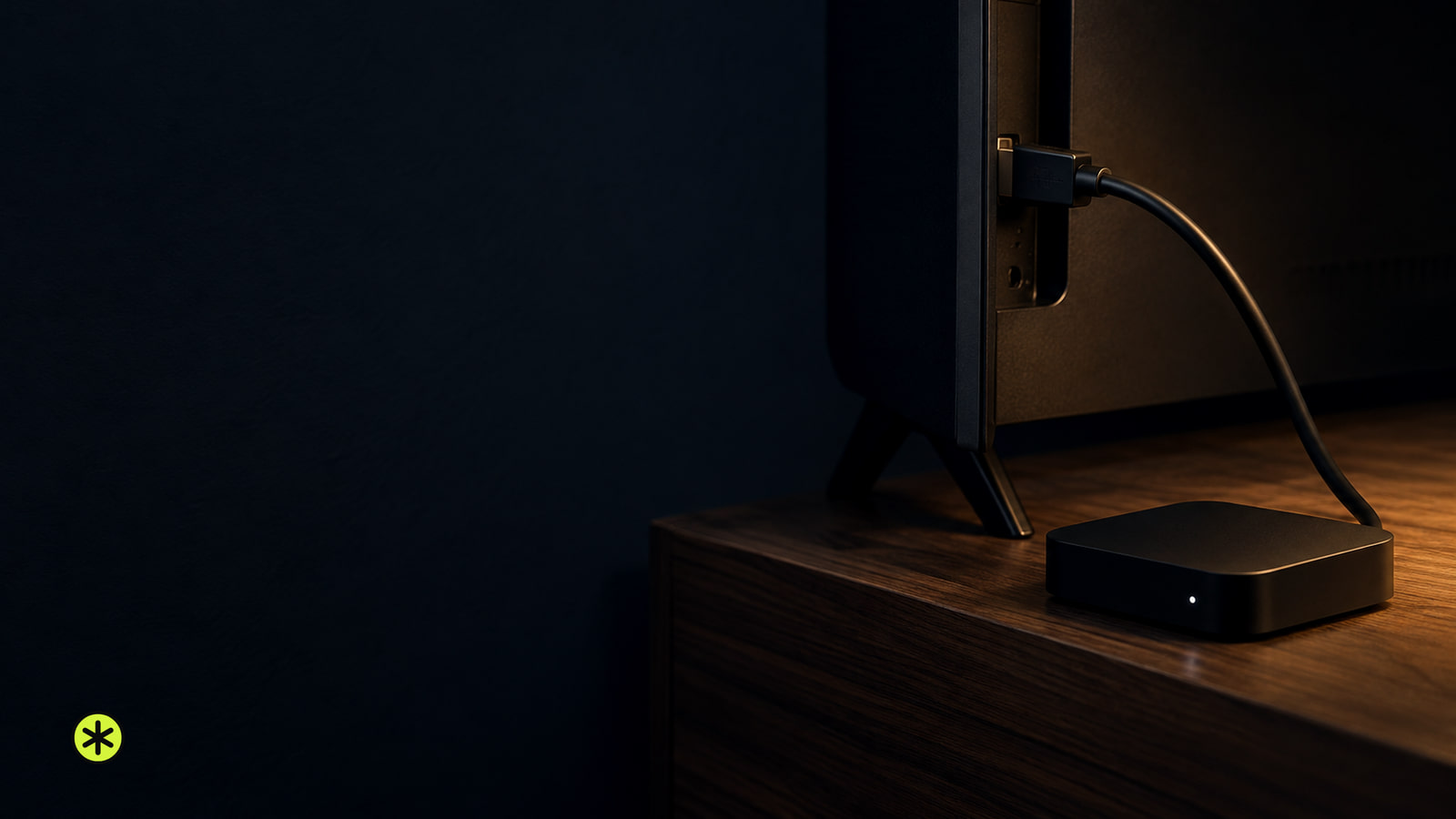 Black HDMI cable plugged into a television's back, running to a small black media player with a white light on a walnut console, lit by a warm lamp.