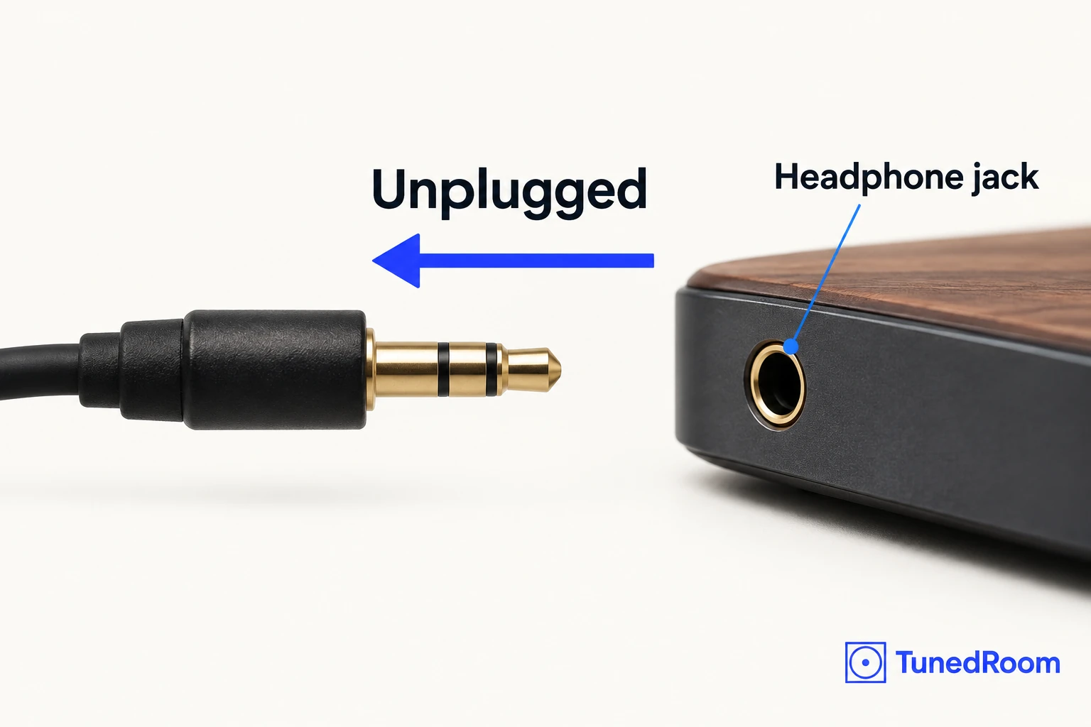 Close-up of an empty headphone jack on a device edge, with the plug pulled clear and a removal arrow pointing away from the socket.