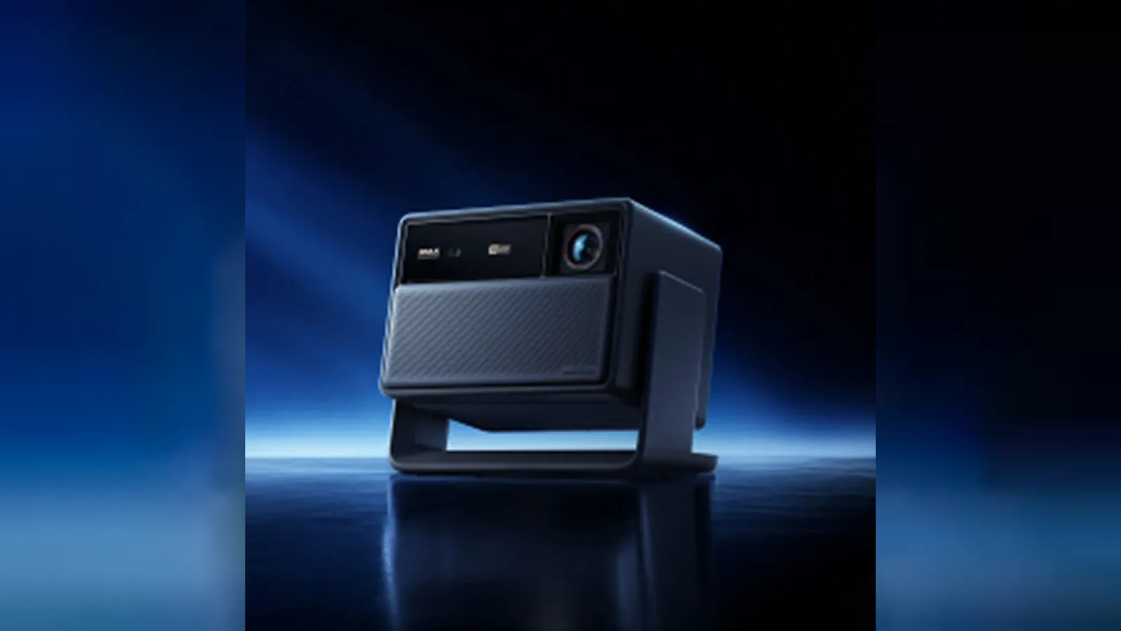 A dark projector with a front lens and broad grille sits on a pivoting stand.